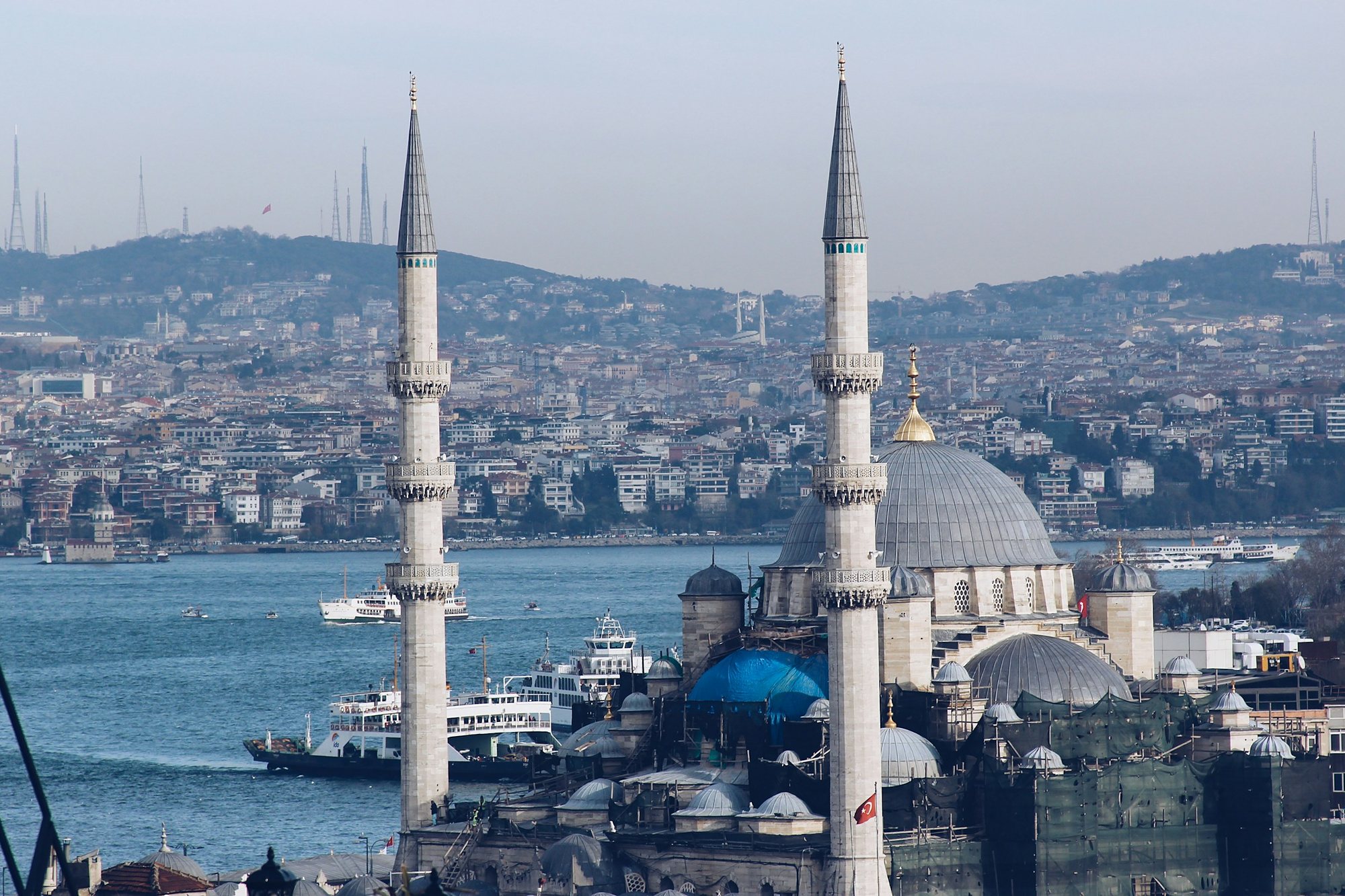 The minarets of the New Mosque with ferries crossing the Bosphorus behind