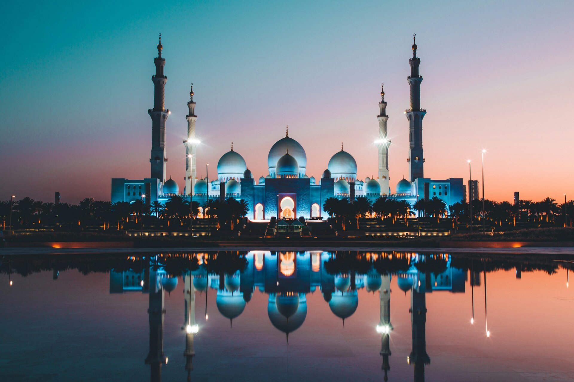 The Sheikh Zayed Grand Mosque lit at dusk and reflected in its pools, Abu Dhabi