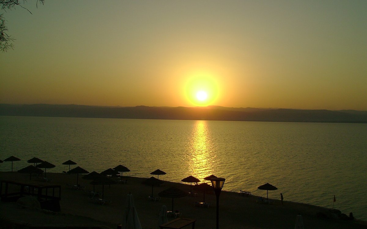 Sunset over the Dead Sea from the Jordanian resort shore at Sweimeh, where the Kempinski Ishtar terraces step down to the water