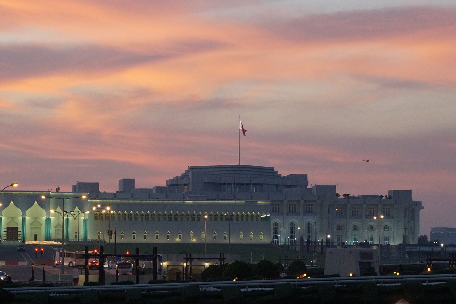 The Amiri Diwan, seat of Qatar's Amir, under a pink sunset sky on the Doha Corniche