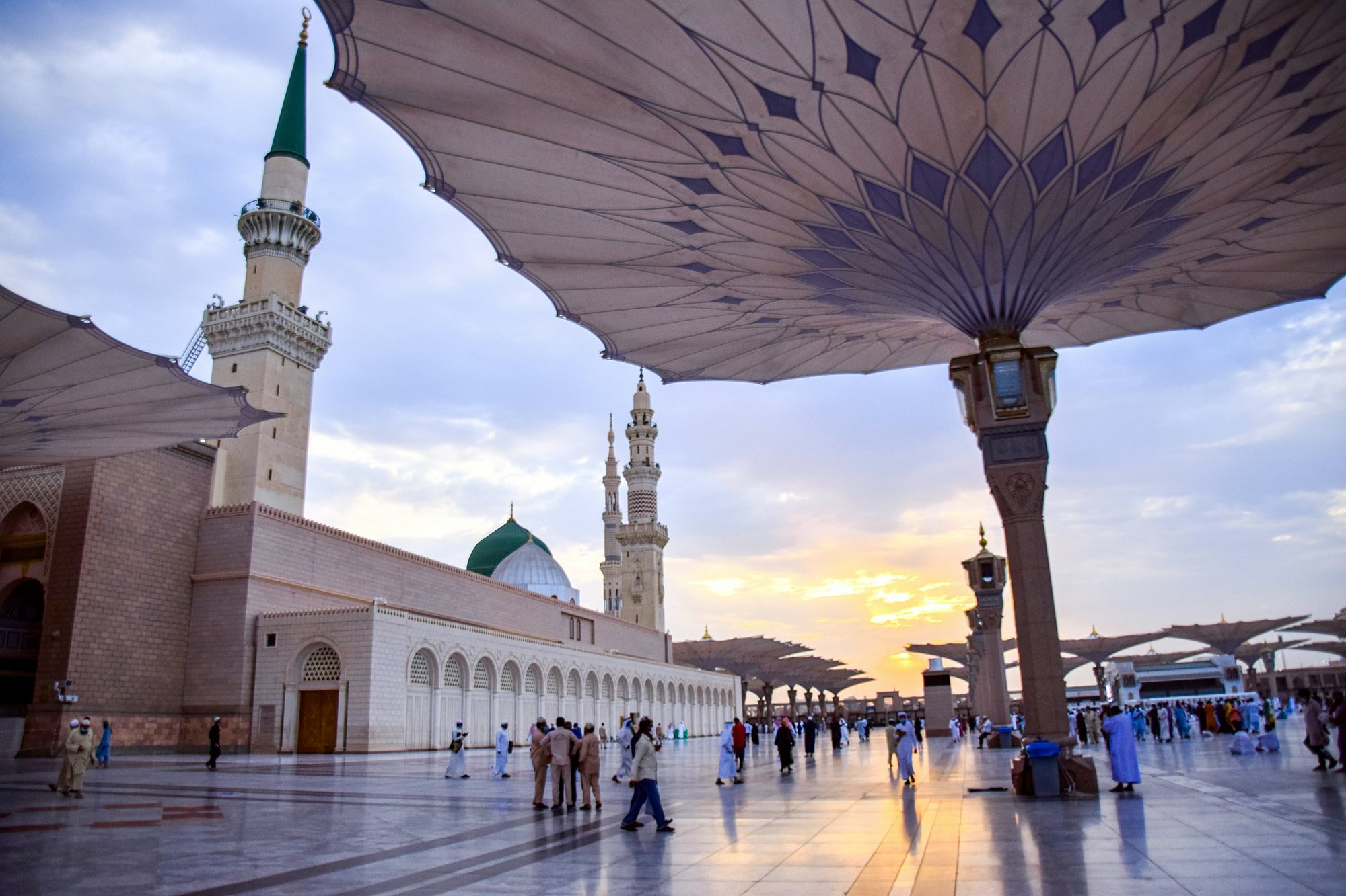 The Green Dome and minarets of the Prophet\u2019s Mosque under its great umbrellas at sunset