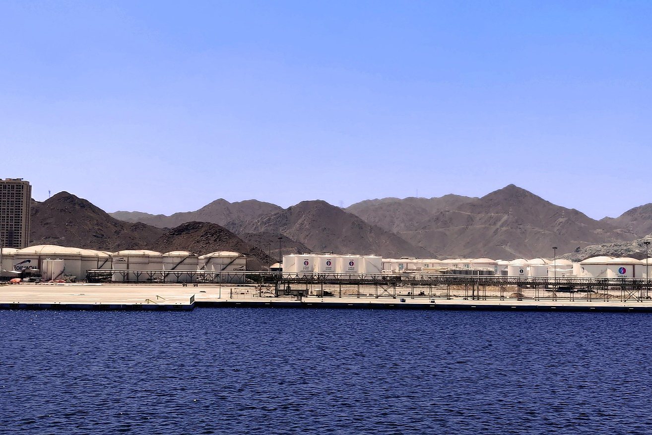Oil storage terminals along the quay at the Port of Fujairah, below the Hajar Mountains