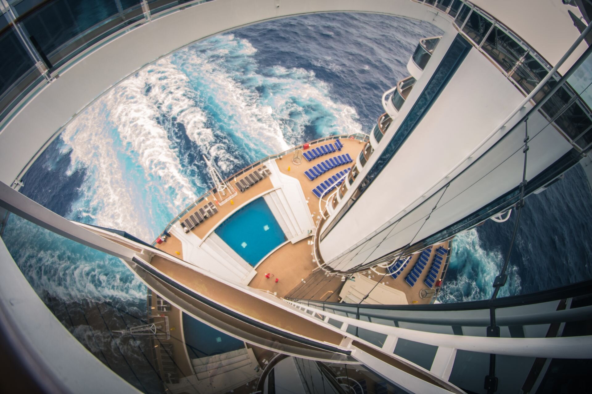 Looking down on a cruise ship's stern pool deck and wake at sea