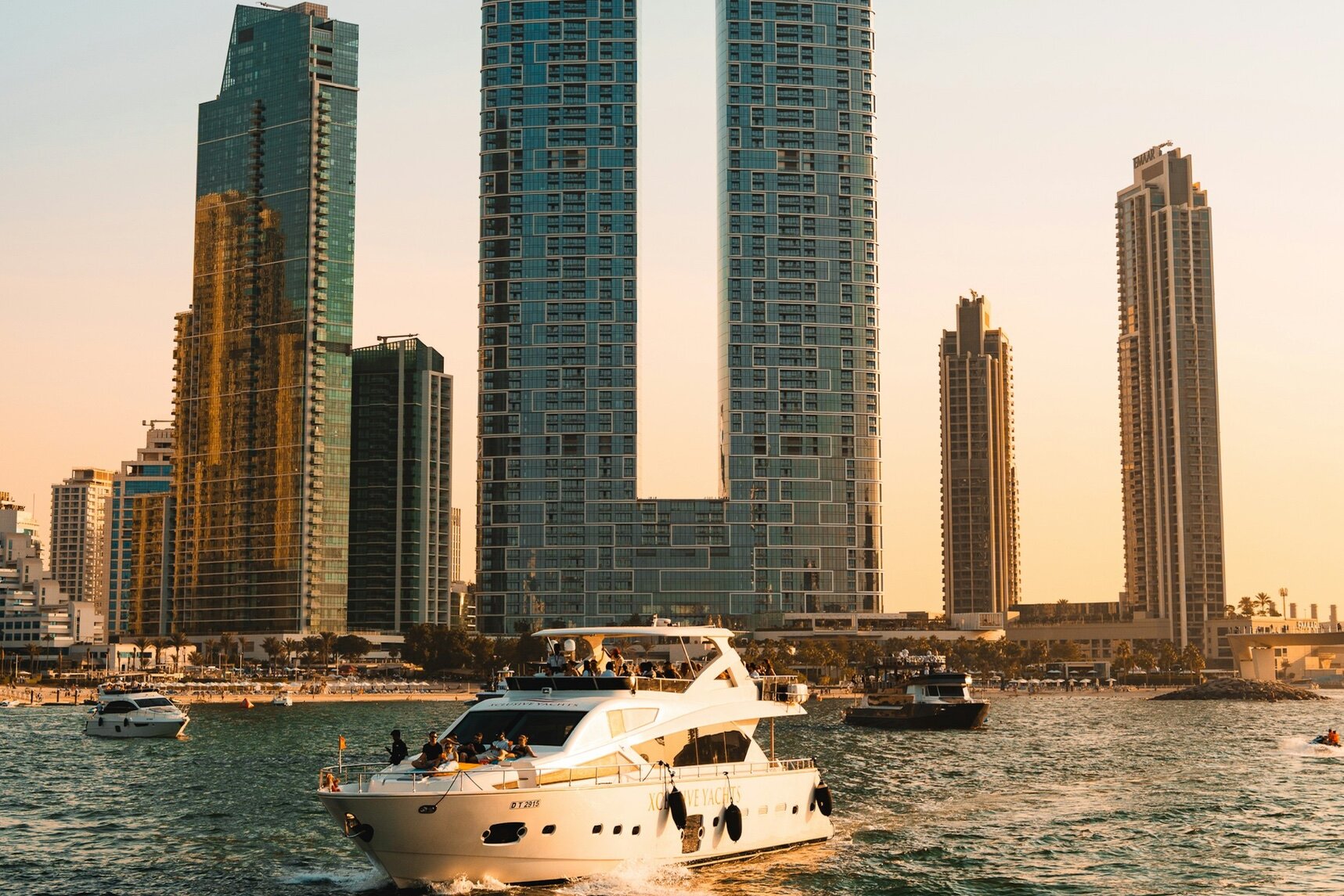 A motor yacht at sunset off Jumeirah Beach Residence, below The Address Beach Resort, Dubai
