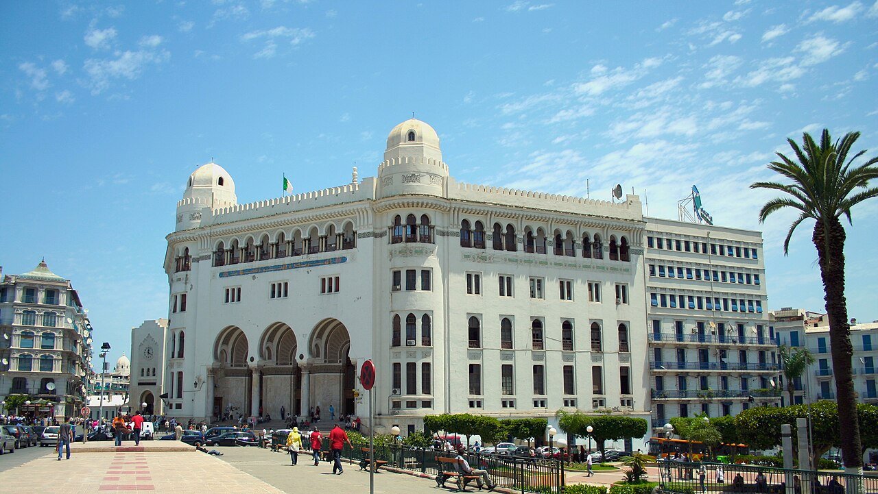 The white neo-Moorish Grande Poste of Algiers, with its domes and arches, beneath a blue sky.