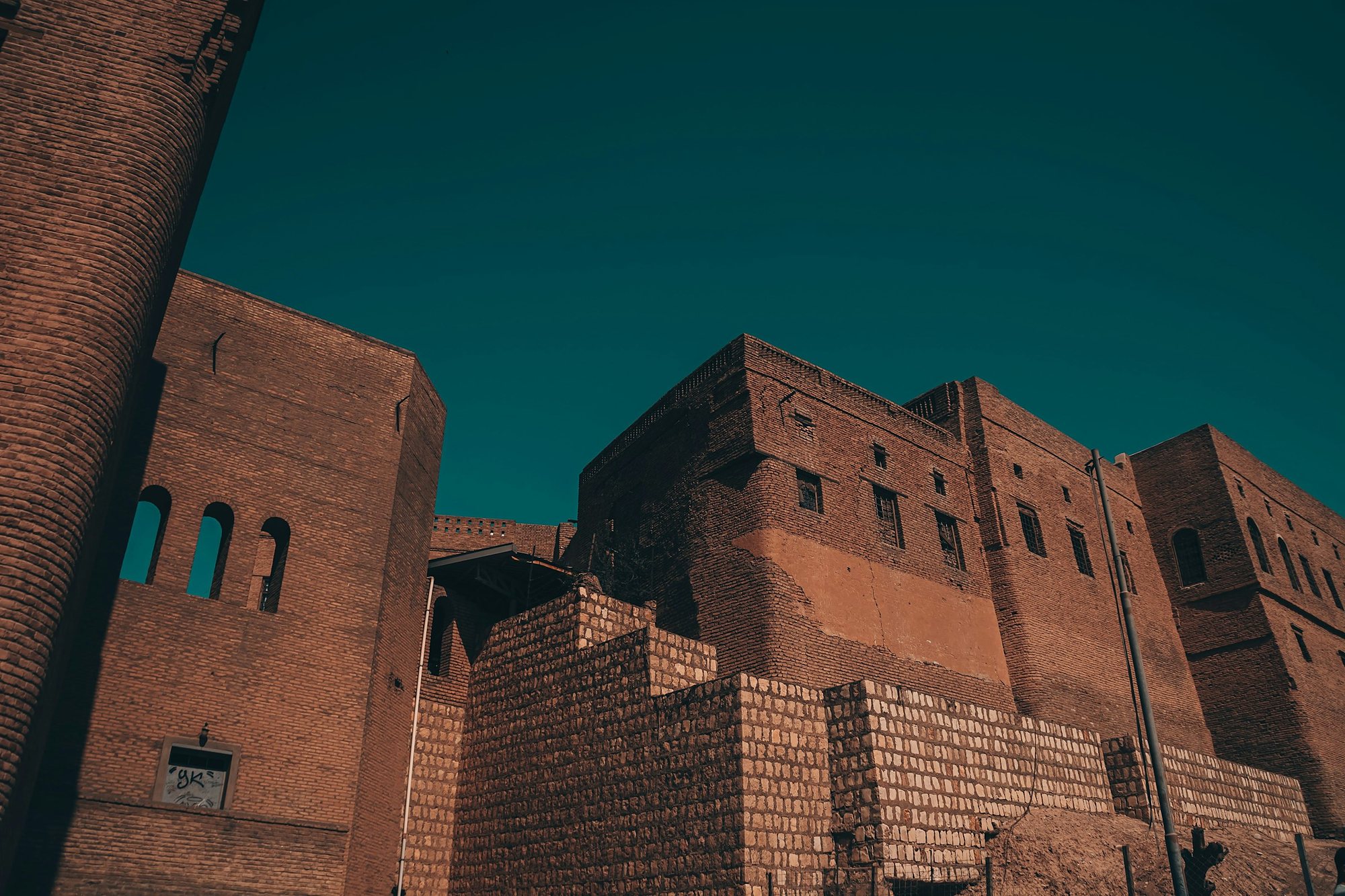 The brick walls of the Erbil Citadel under a deep sky