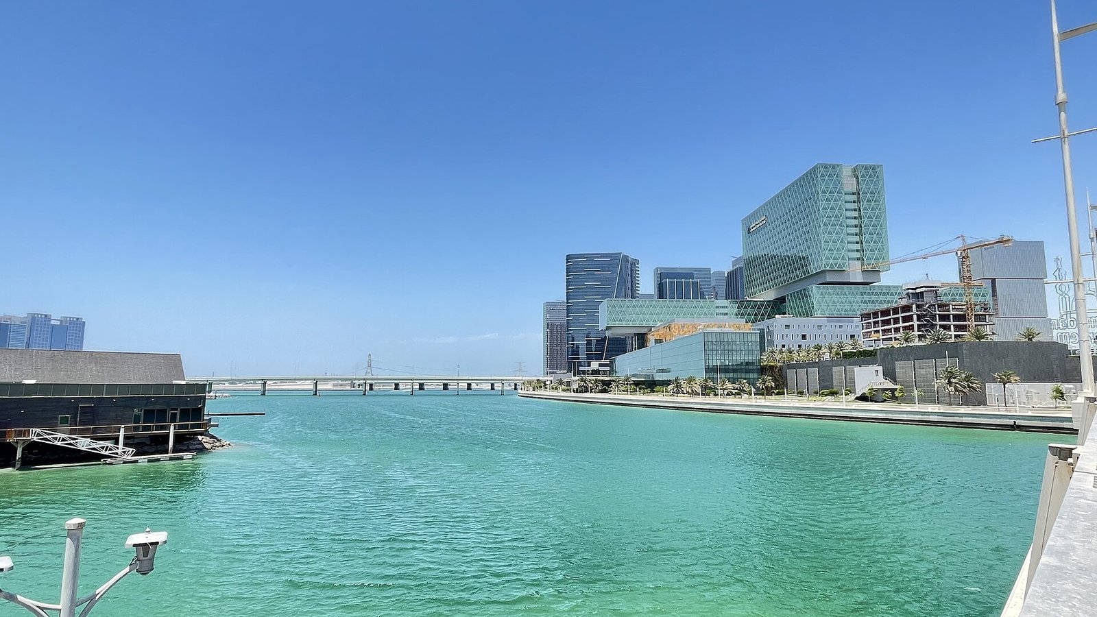 Turquoise water along Al Maryah Island in Abu Dhabi, with the green glass towers of Cleveland Clinic Abu Dhabi