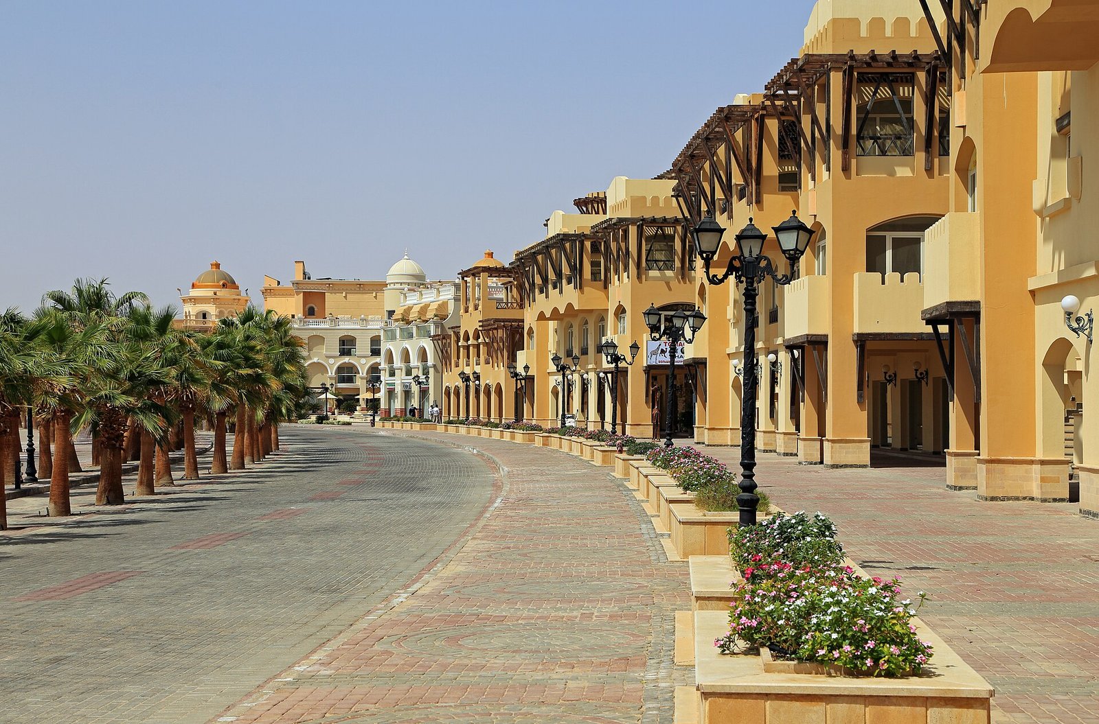 A palm-lined promenade of arcaded resort buildings at Sahl Hasheesh on Egypt's Red Sea coast.