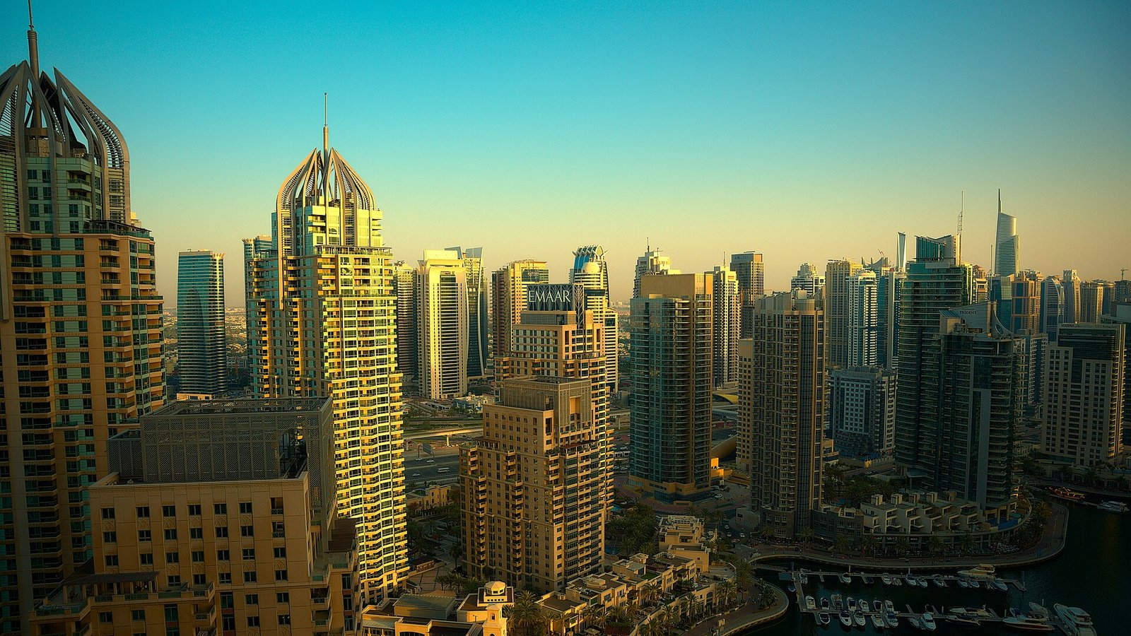 The towers of Dubai Marina bathed in warm late-afternoon light.