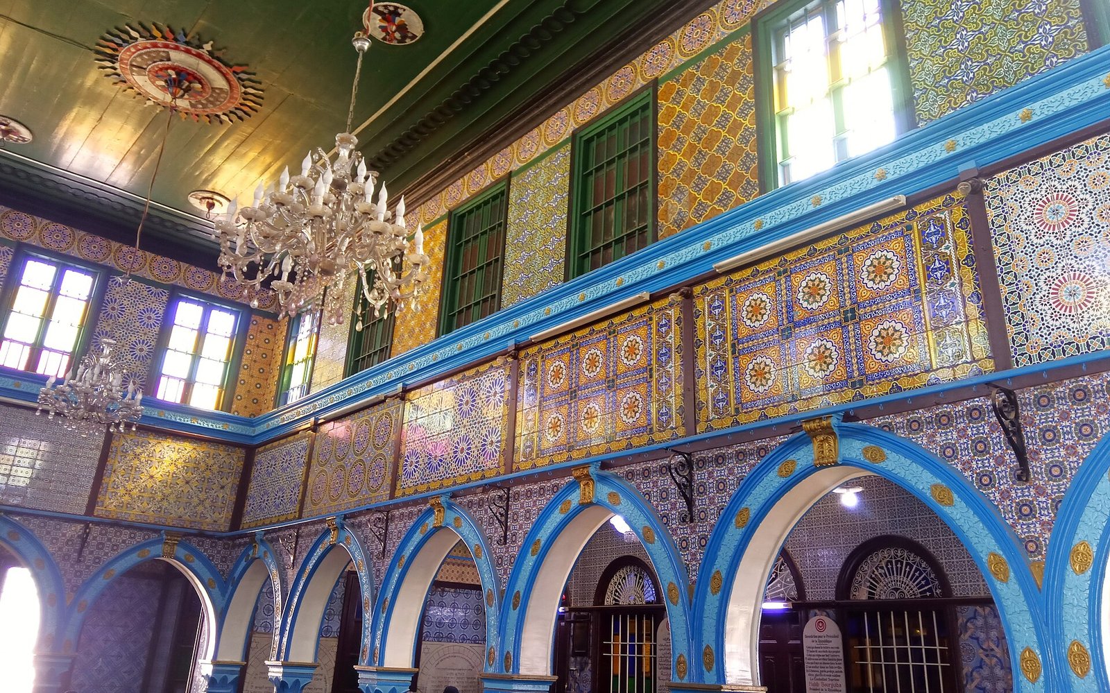 Blue arches, painted tiles and crystal chandeliers fill the interior of the El Ghriba Synagogue on Djerba, Tunisia.