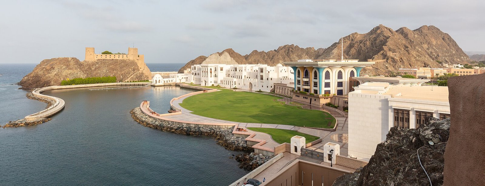 Al Alam Palace in Muscat on its bay, with the Al Jalali fort and rugged mountains beyond
