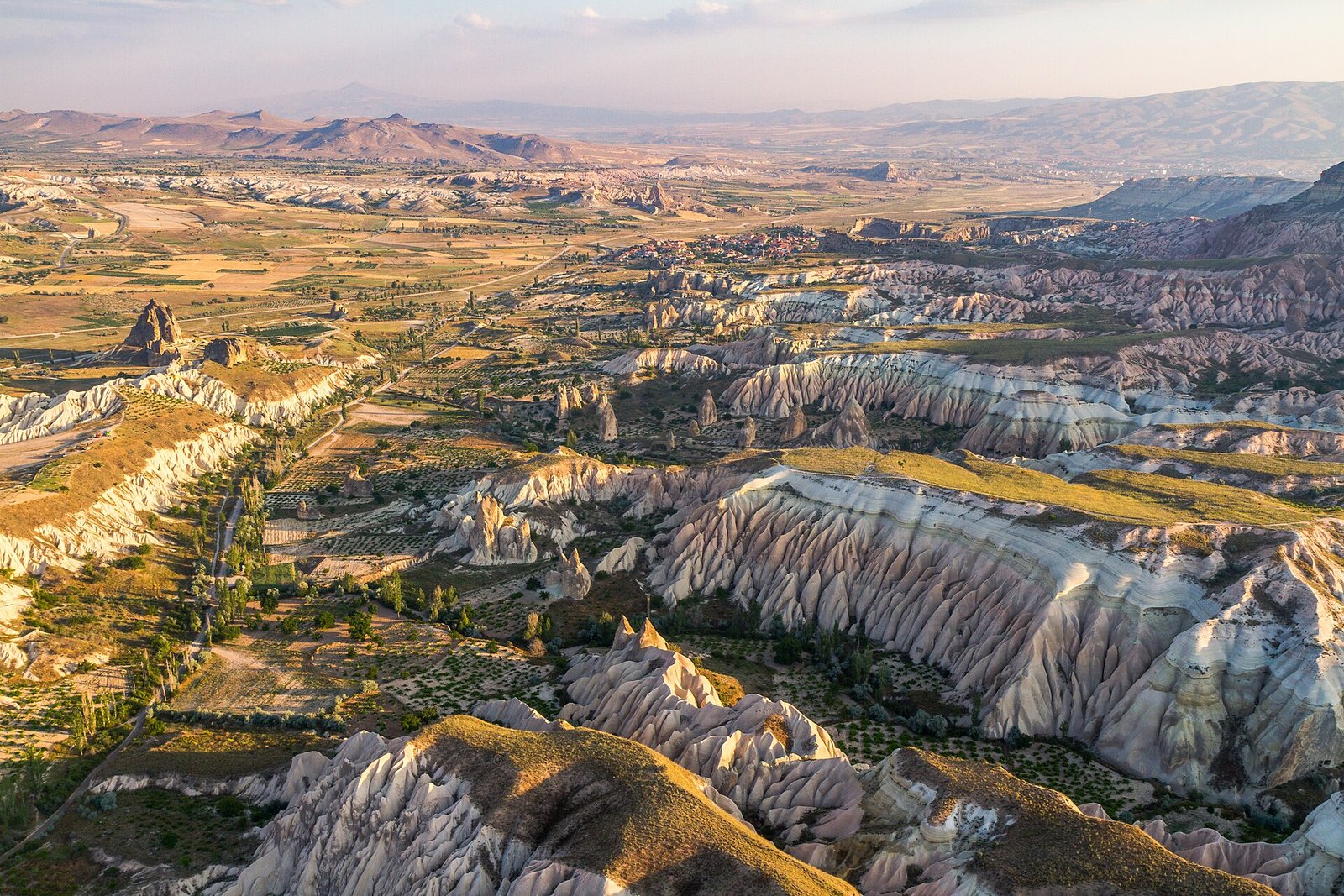 The valleys and rock ridges of Cappadocia near Göreme in warm early light, seen from the air