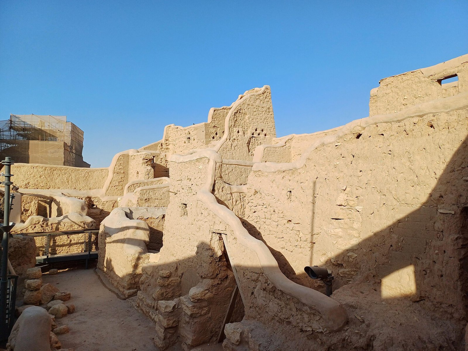 Weathered mud-brick walls of the At-Turaif district in Diriyah, Riyadh, under a deep blue sky.