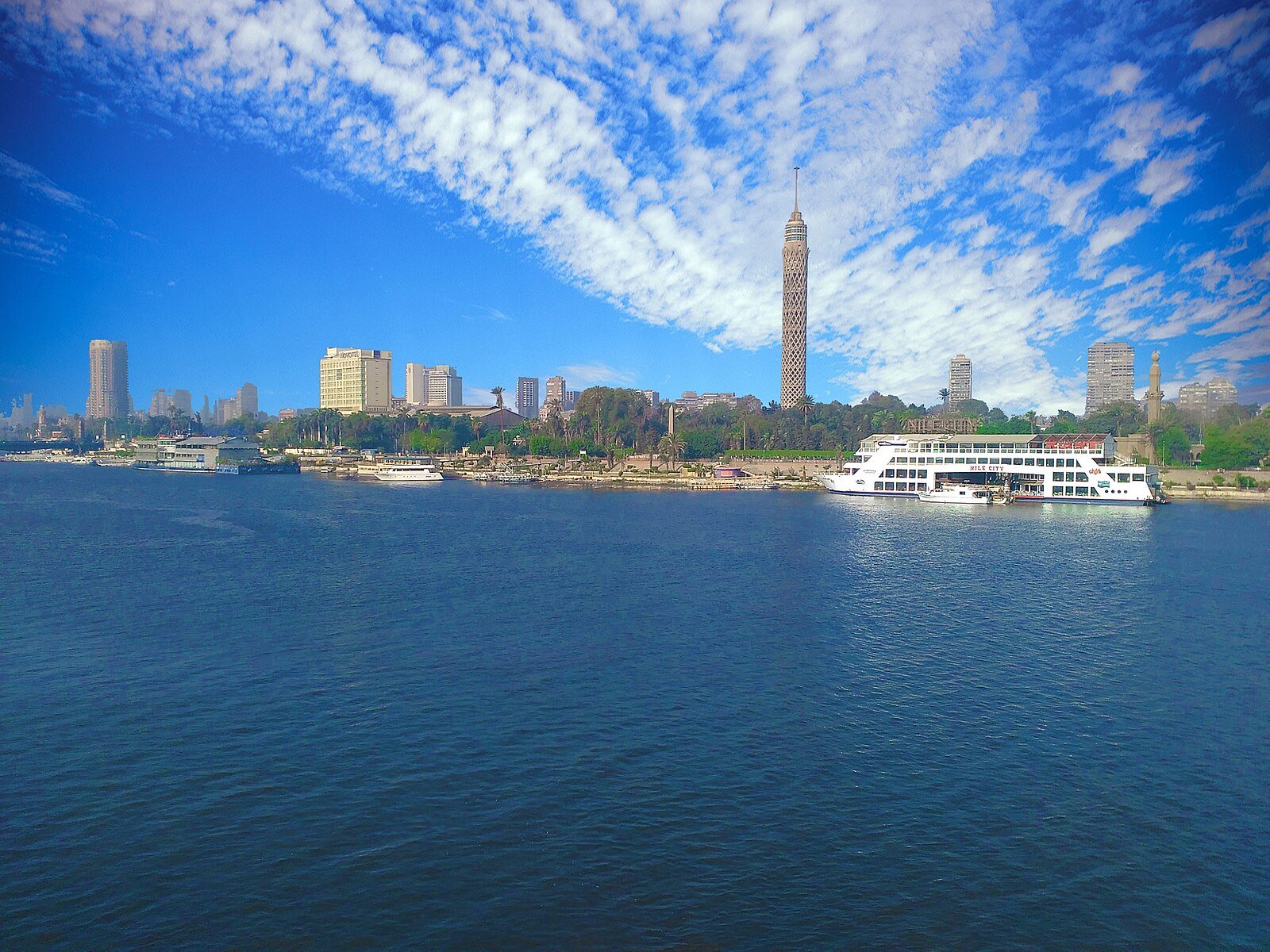 The Cairo Tower rising above Gezira Island and the deep-blue Nile under a sky of scattered white cloud