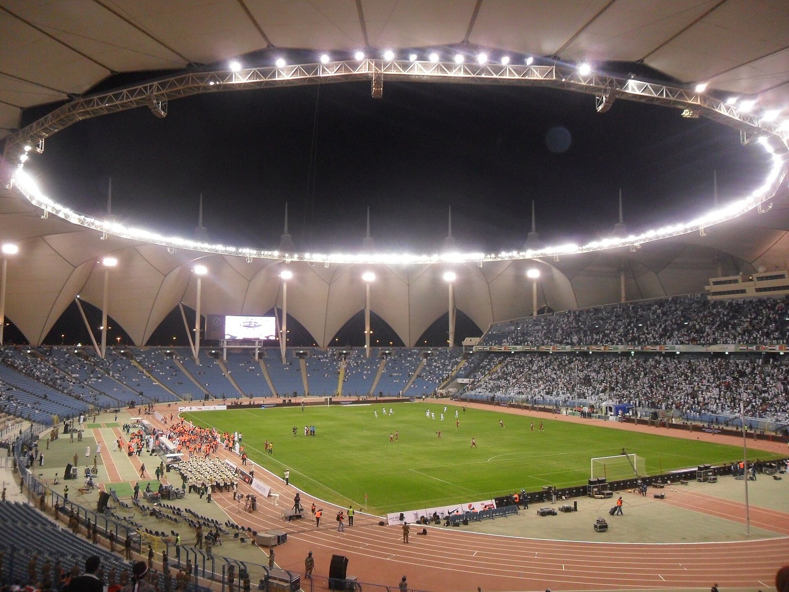 King Fahd International Stadium in Riyadh, its tented roof ringed with floodlights on a match night.