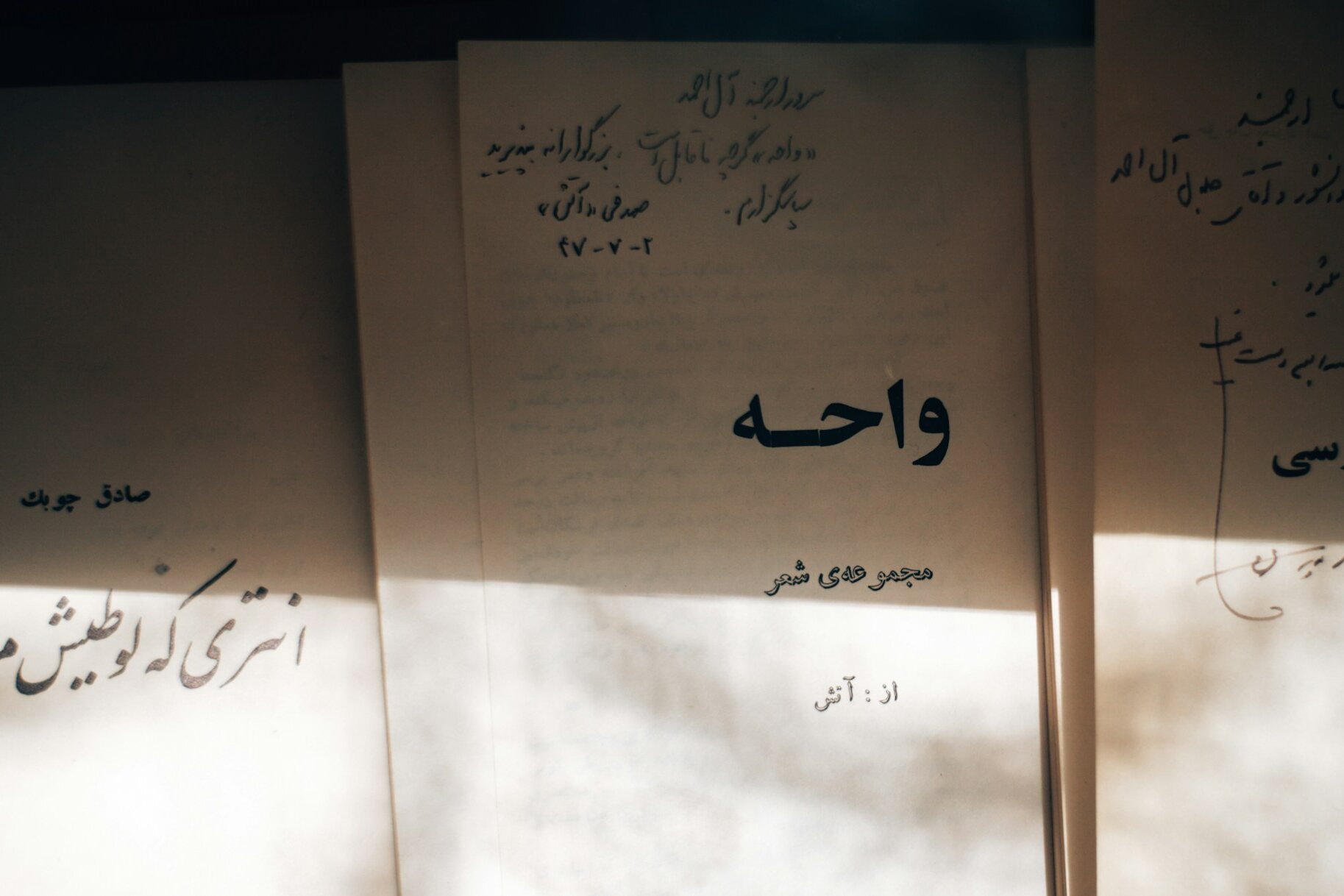 Persian books with handwritten inscriptions in the afternoon light