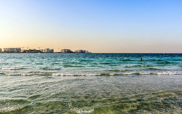 Jumeira Bay island seen across the water from a Jumeirah beach at sunset