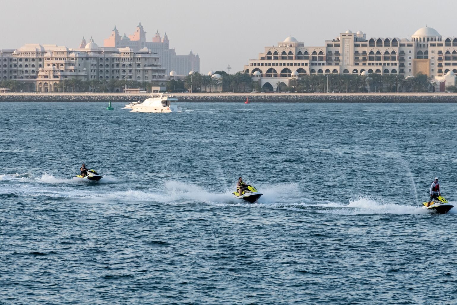 Jet skis off the Palm Jumeirah, with Atlantis and the palace hotels beyond, Dubai