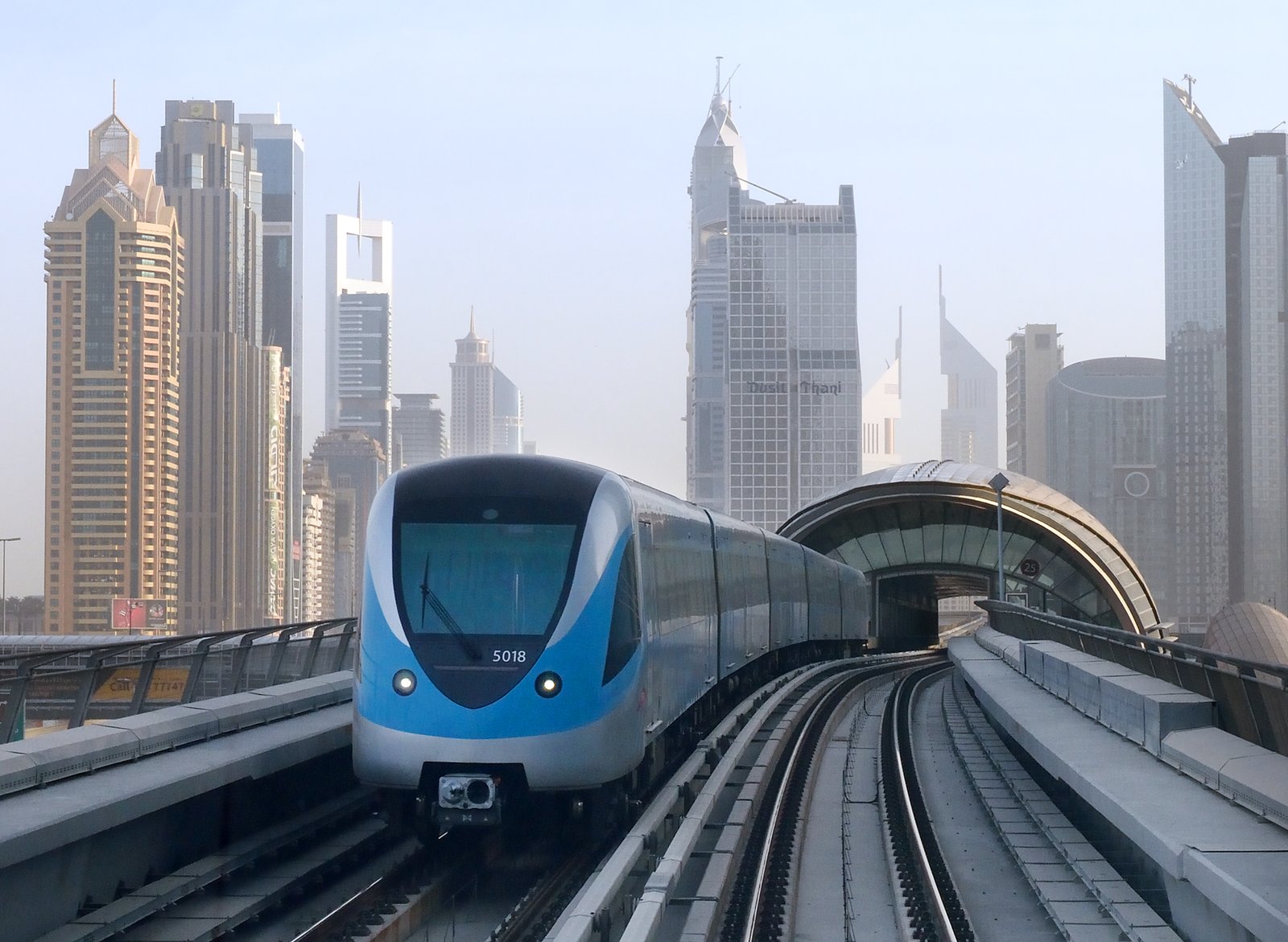A Dubai Metro train gliding along its elevated track between the towers of Sheikh Zayed Road