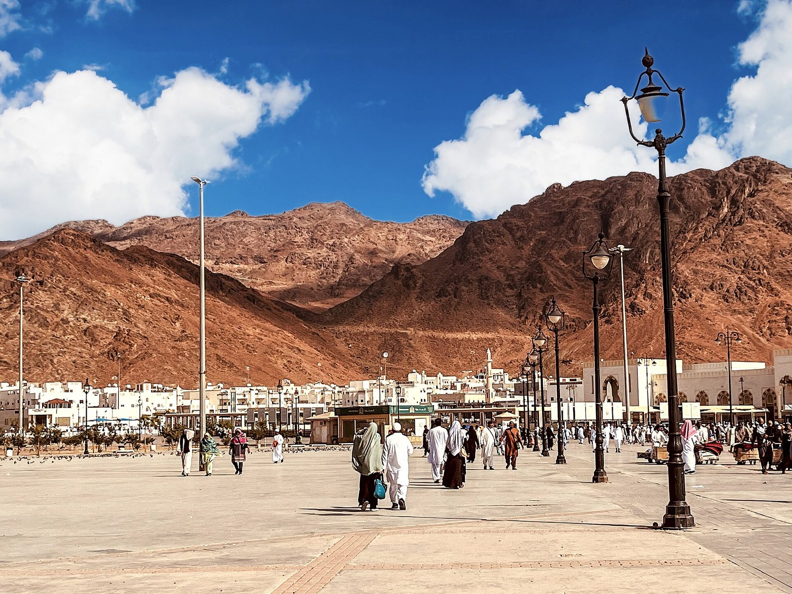 The red granite ridges of Mount Uhud rising above a broad plaza on the northern edge of Madinah