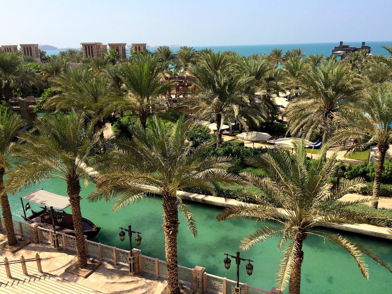 Palm-shaded waterways and gardens winding through the Jumeirah Al Qasr resort at Madinat Jumeirah, Dubai
