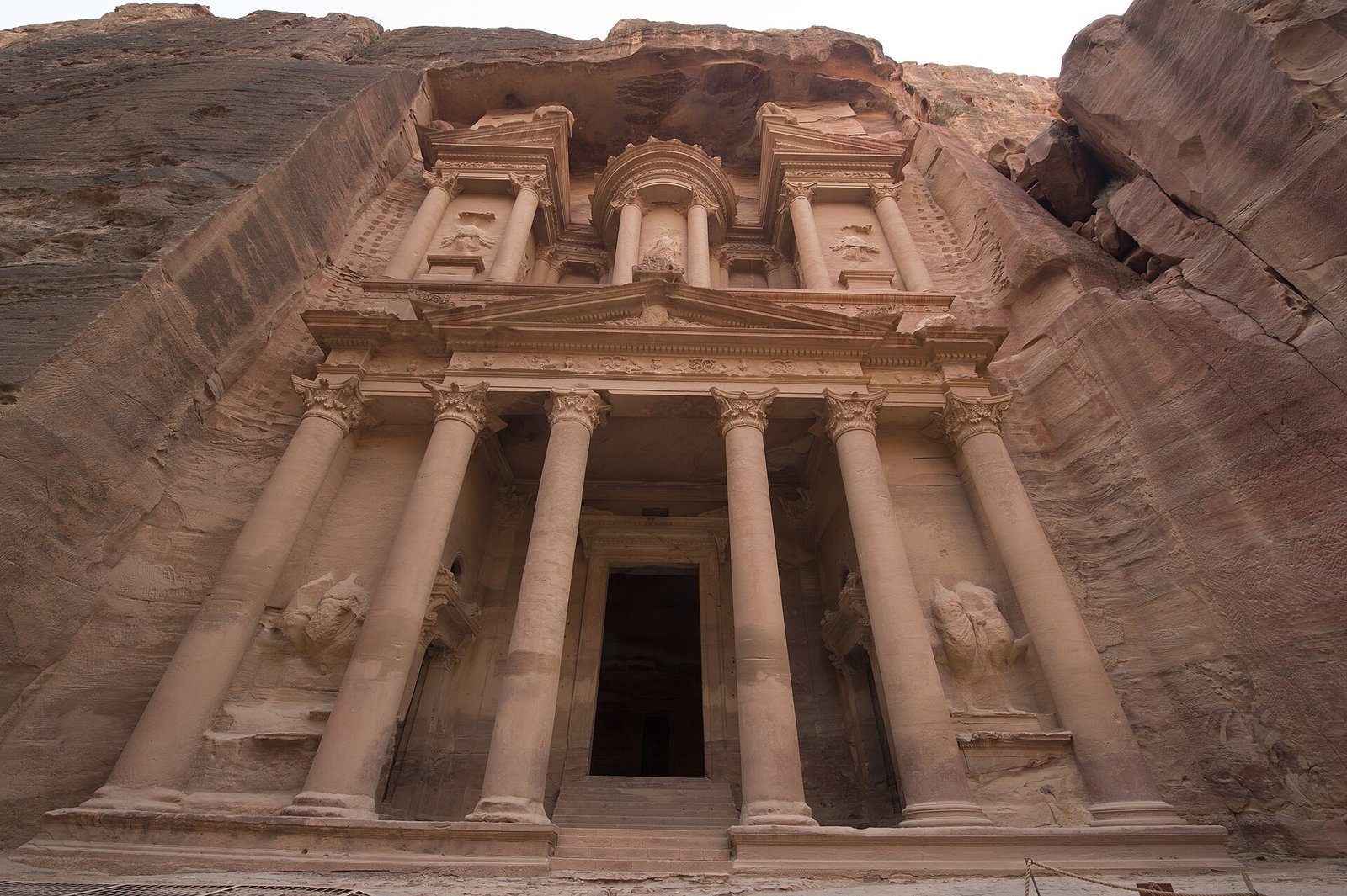 The rose-red facade of Al Khazneh, the Treasury, carved into the sandstone cliffs of Petra, Jordan.