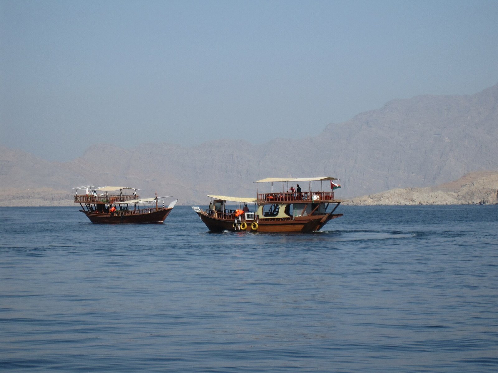 Traditional dhows cruising the calm waters of the Musandam fjords, Oman