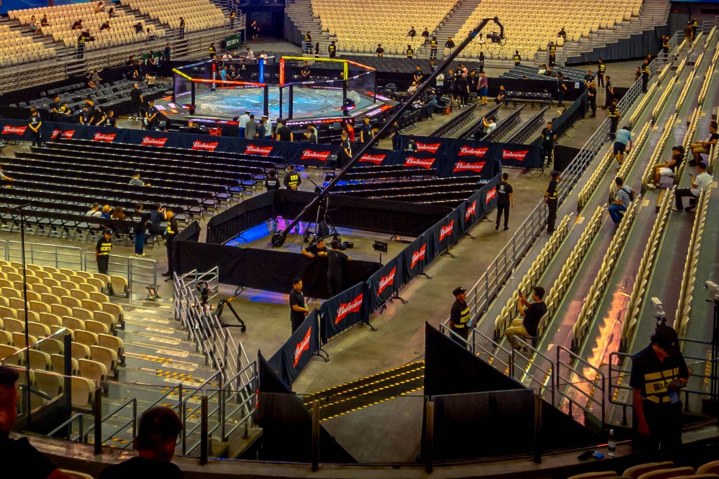 An arena set for fight night, the octagon lit at ringside