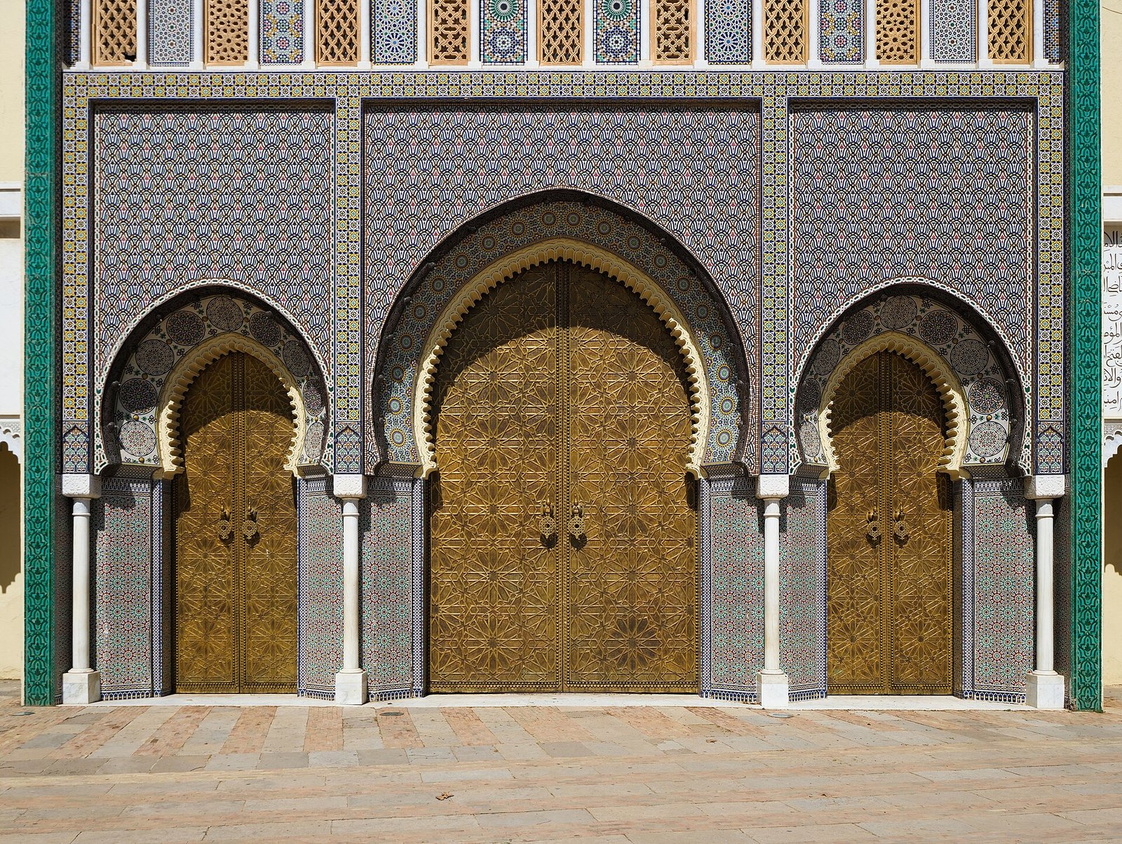 The gilded brass doors and zellige tilework of the gates of the Royal Palace, Fez.