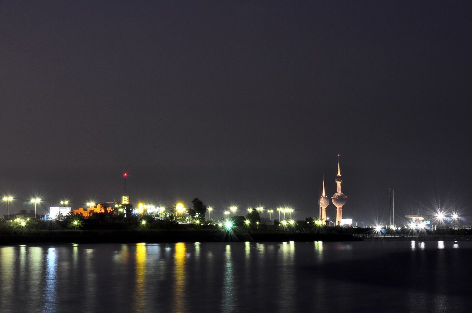 The illuminated Kuwait Towers and the lights of the Gulf shore at night, Kuwait City