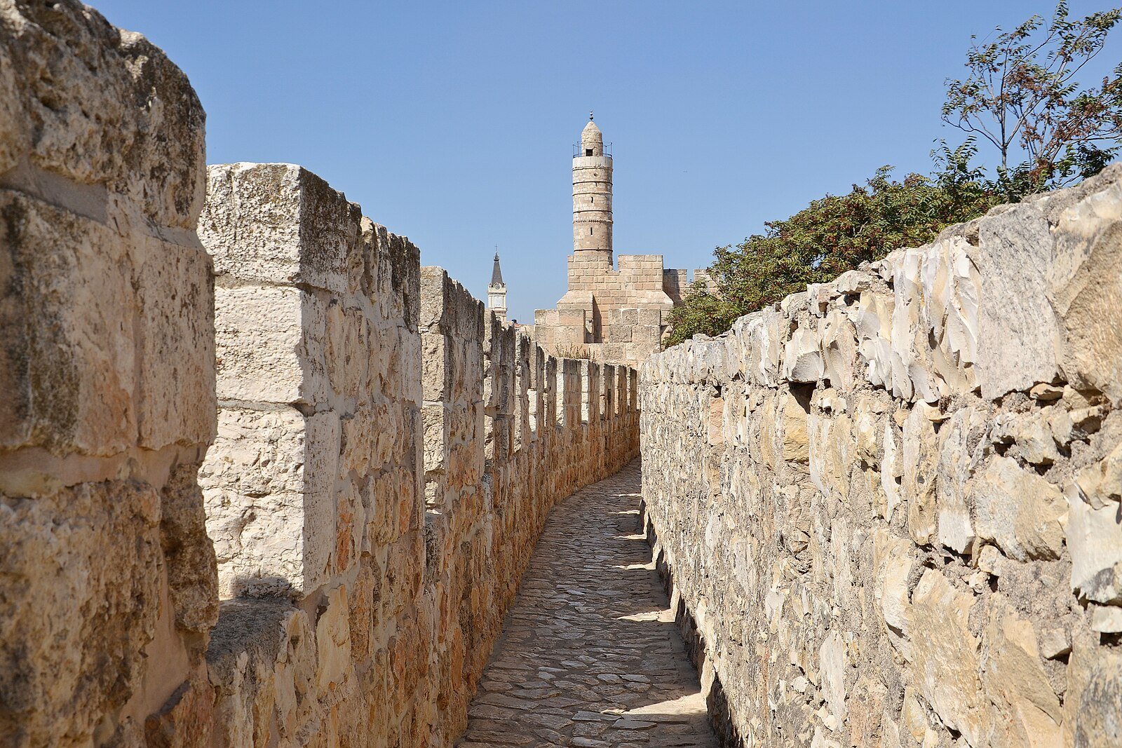 The rampart walk along Jerusalem's Old City walls leading toward the minaret of the Tower of David.