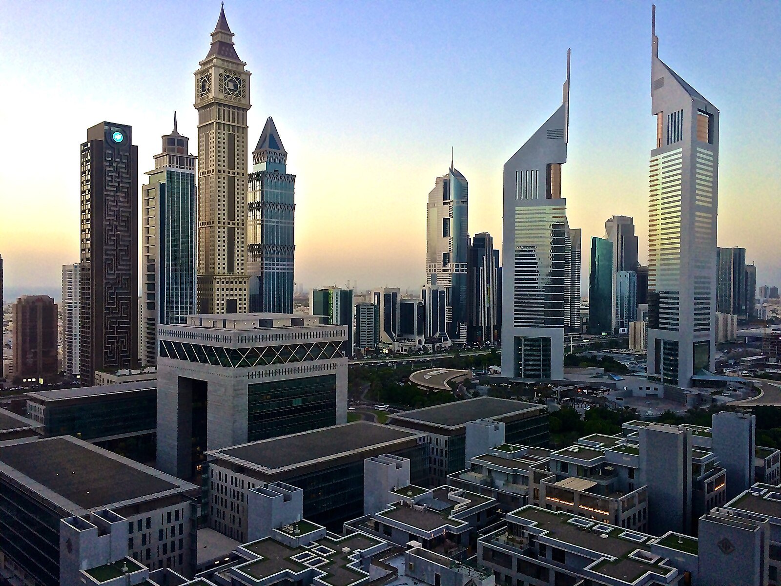 The Emirates Towers and the Gate Building of the Dubai International Financial Centre in the soft light of dawn.