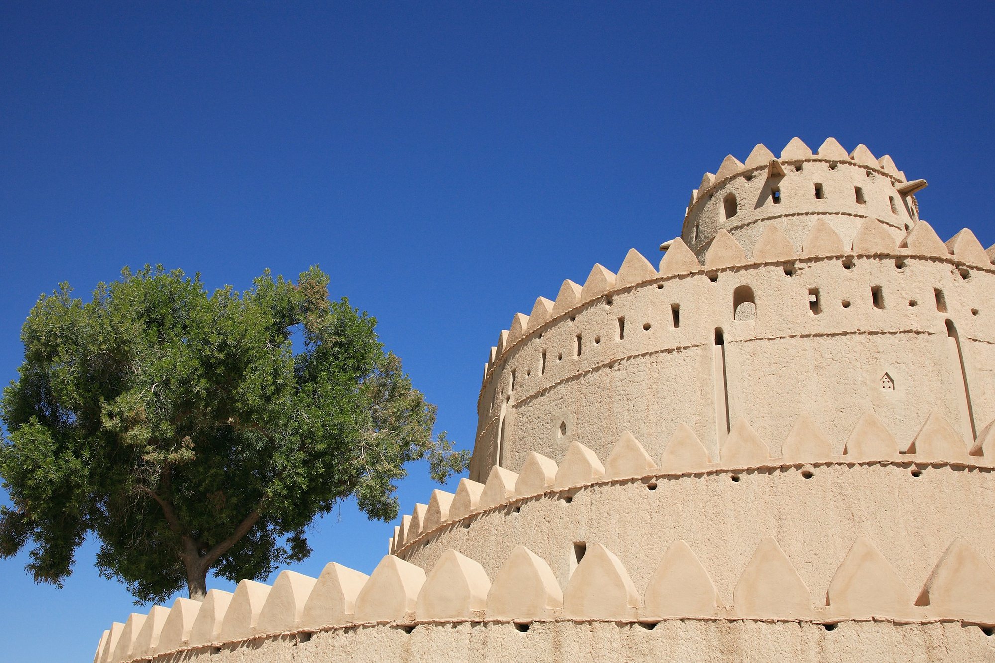 The round tower of Al Jahili Fort in Al Ain under a blue sky