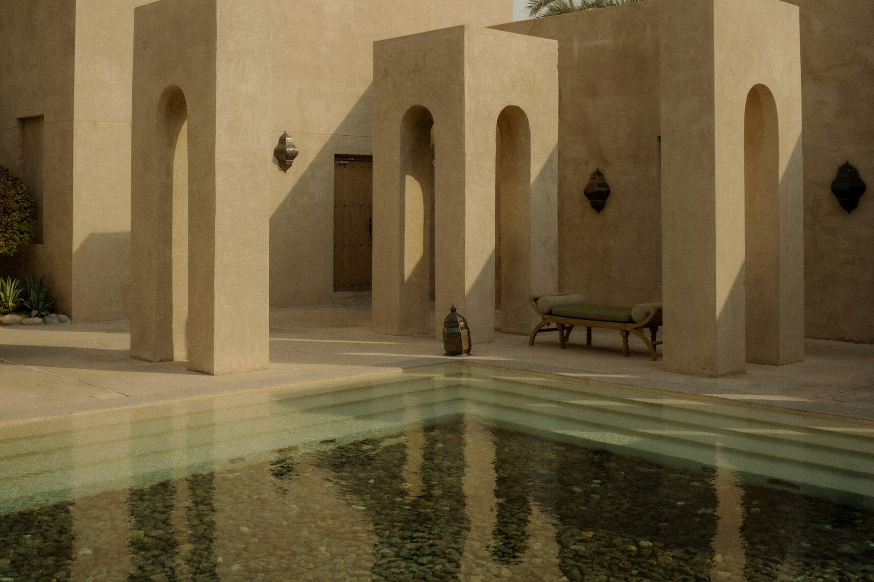 Arched pavilions and a still courtyard pool at Bab Al Shams in the desert outside Dubai