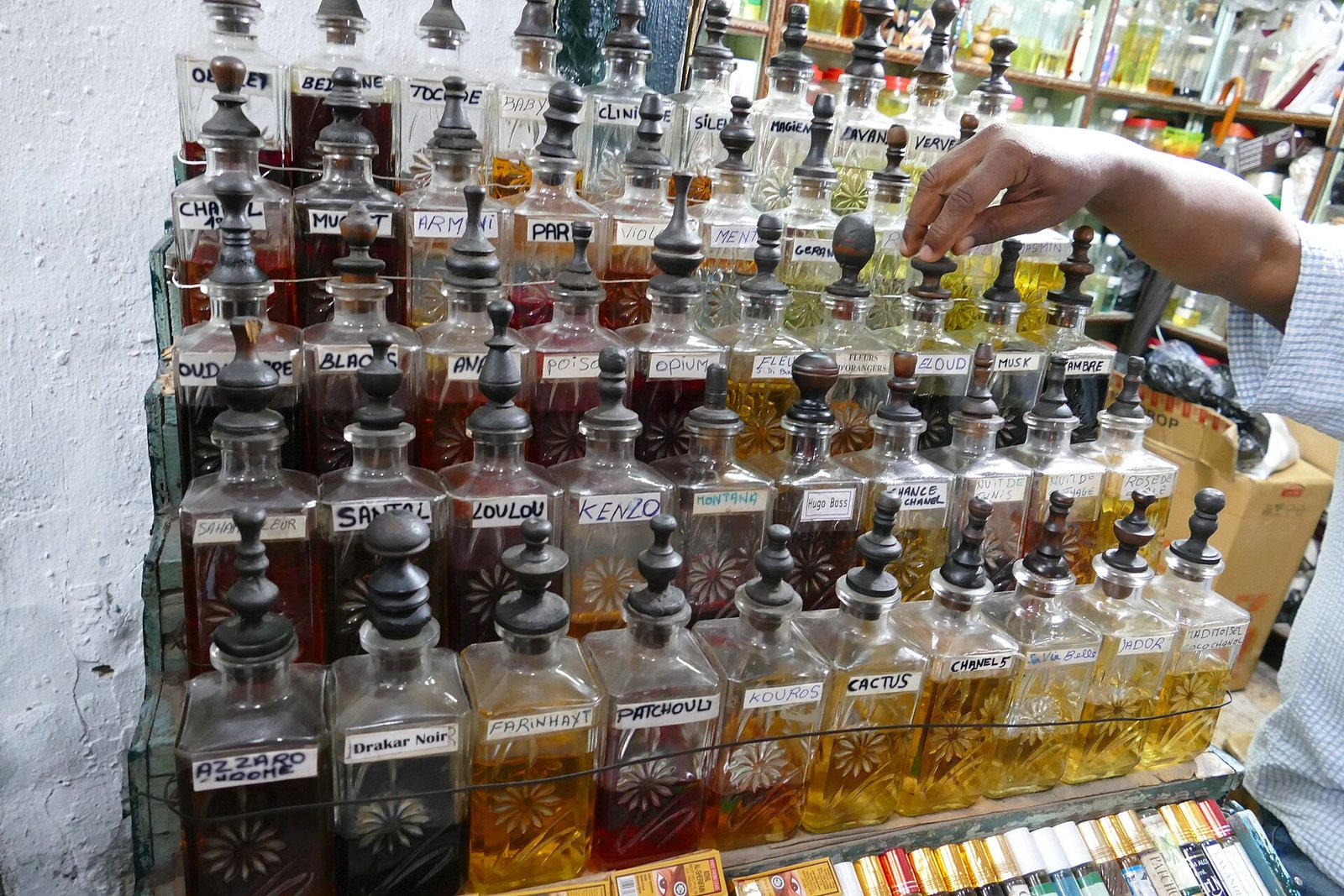 Rows of cut-glass decanters filled with amber perfume oils in a traditional souk perfumery.