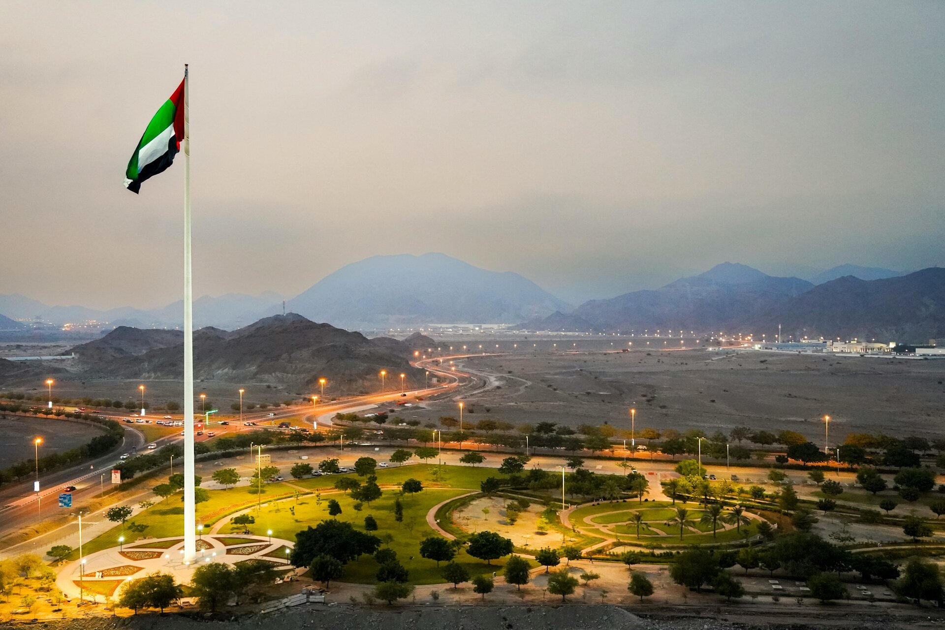 The UAE flag flying over a park below the Hajar Mountains, Fujairah