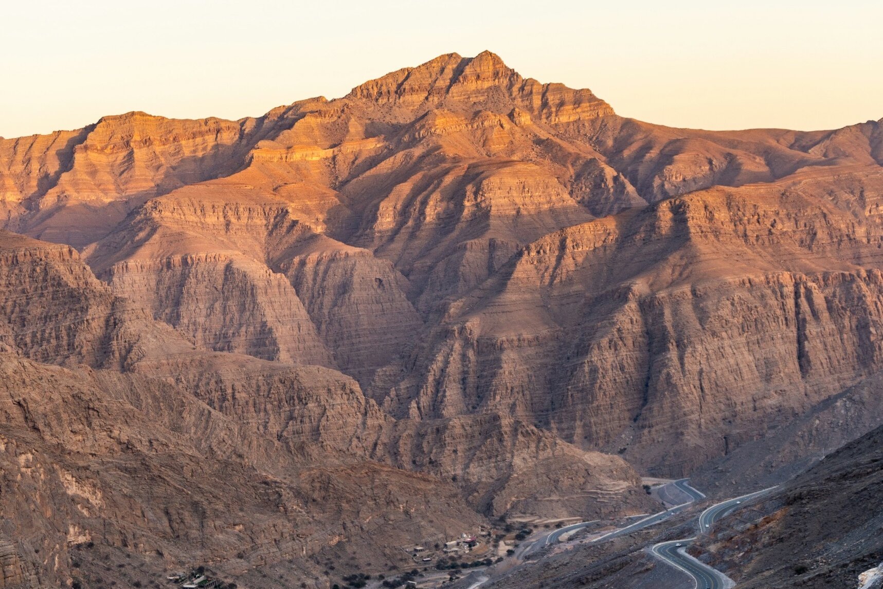 Jebel Jais at golden hour, the mountain road winding up through Ras Al Khaimah